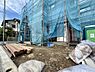外観：建築中の建物を覆う青い養生シートと資材