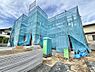 外観：青い養生シートで覆われた建築中の建物