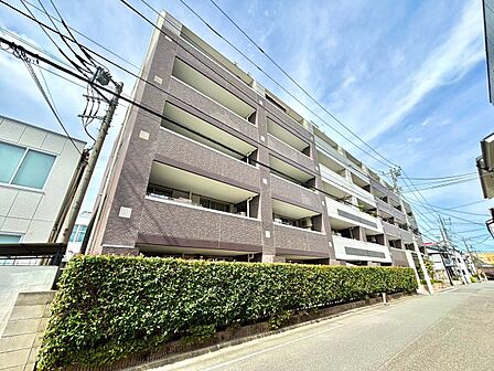 白い外壁とバルコニーが特徴のマンション外観