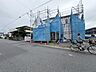 外観：道路沿いの建築中物件青い養生シートで覆われている