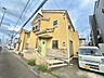 外観：黄色い外壁の2階建て住宅と前面道路