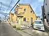 外観：住宅街に建つ黄色い戸建て住宅と前面道路