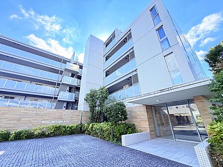 植栽と駐車スペースを備えた集合住宅の外観