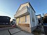 外観：白い外壁の戸建て住宅と前面の舗装スペース