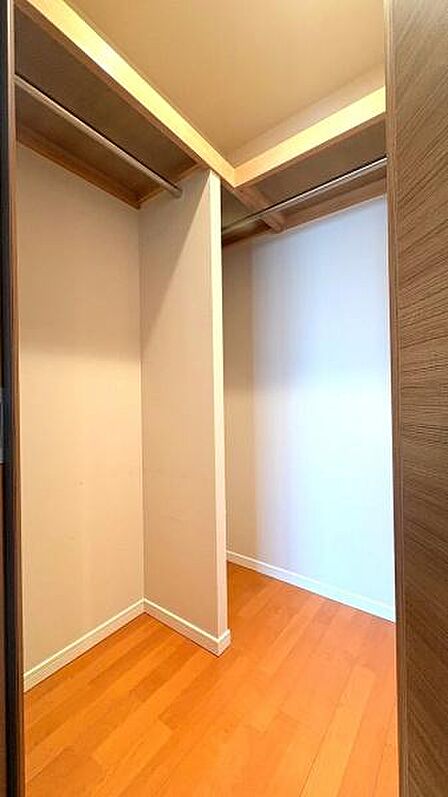 【収納】ハンガーパイプや上部棚を備えたL字型のウォークインクローゼット。丈の長い衣類やバッグなどもスッキリと収納できます。※写真はリフォーム前のものとなります。
