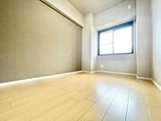 木目のフローリングが暖かみのある室内に。明るい寝室で心地のいい朝を迎えられそう。