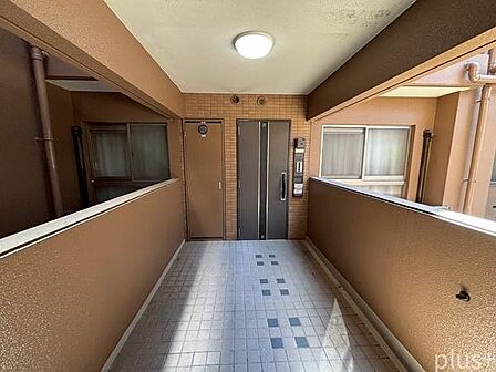 玄関前には専用ポーチを設置。共用廊下との間にスペースがあり、独立感のある玄関まわりです。