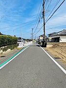 前面道路が広く車両の通行もスムーズに行えます。周辺は落ち着いた雰囲気で住宅が立ち並び安心感があります。現地写真から道路の整備状況がよくわかります。電柱や歩道のラインも見やすく日当たりも確認できます。