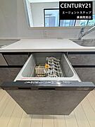 食洗機が備わったキッチンとなっております。シンプルで使いやすい設計が特徴です。ゆとりのある作業スペースも確保されています。キッチンの収納も充実しています。窓があり明るさも感じられる空間です。