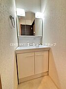 清潔感のある洗面台が設置されています。収納スペースも十分にあり毎日の身支度に便利です。ミラーの上下に照明があるため明るい空間になっています。シンプルなデザインが特徴的です。