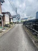 前面道路は舗装されており歩行や車両の通行がしやすい環境です。周囲には住宅が並び落ち着いた雰囲気を感じられます。周辺の建物もしっかりと管理されている印象です。電柱や電線も整然と配置されています。