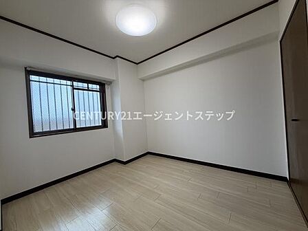 シンプルな内装で家具やインテリアを自由にコーディネートしやすい寝室です。窓からの採光が良く明るさが感じられます。床の色合いも落ち着いており清潔感が漂います。収納スペースも確保されています。
