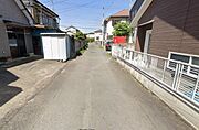 現地前面道路は幅員がしっかり確保されており車両の進入や駐車もスムーズに行えます。住宅街に位置しているため周囲は落ち着いた雰囲気です。両側に住宅やフェンスが並びプライバシーにも配慮されています。