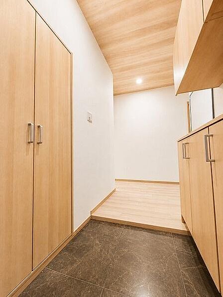 【一部家財撤去後イメージ写真】自宅の顔である玄関は木目でシンプルながらも暖かさのある仕様、大人がすれ違える広さは、朝の身支度のストレスがございません。