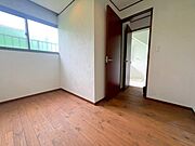 【洋室】洗面室に隣接する、約5帖の地下1階洋室です。窓から自然光が差し込み、地下でありながら明るく快適な居室空間です。