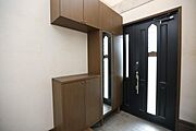玄関にはたっぷり収納できるシューズボックスが設置されています。鏡付きでお出かけ前のチェックにも便利です。ドアは採光窓付きで明るさを確保しています。シンプルなデザインが特徴的です。