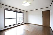 大きな窓からたっぷりと自然光が入る洋室です。木目調の床が落ち着いた印象を与えます。ホワイトの壁と天井で室内がすっきりしています。シンプルな内装なのでさまざまなインテリアが楽しめます。