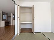 収納スペースには棚が設置されており小物から衣類まで整理しやすい仕様です。扉が大きく開くため内部のものを出し入れしやすい点も魅力です。室内の色調と統一された収納デザインがすっきりとした印象を与えます。
