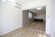 引き戸で仕切られた洋室は隣接する空間との一体感を感じられます。シンプルで整った内装が印象的です。明るい床材と白い壁が清潔感を演出しています。天井近くの窓から自然光が入り室内をより明るくします。