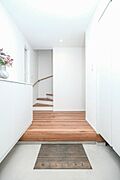 シンプルながら機能的な玄関は、広々とした空間と充実した収納が特徴。日々使う物を収納するのに便利なスペースが確保されています。