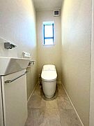 清潔感のある明るいトイレです。スリムな手洗いと収納が設けられています。窓が付いているため自然光が入りやすい設計です。シンプルな内装でお手入れもしやすそうです。