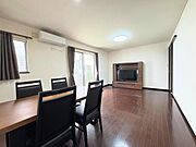 大きな窓から光が差し込む明るいリビングです。広々とした空間で開放感があります。落ち着いた色合いのフローリングが魅力です。テレビボードやテーブルセットなど家具が配置しやすいレイアウトです。