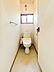 トイレ：トイレはシンプルな設計で使いやすさが感じられます。窓からは自然光が入るため明るい空間になっています。ペーパーホルダーが壁面に備え付けられており機能的です。