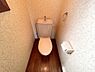 トイレ：温かみのある木目調の床が特徴のトイレです。シンプルな設備で使いやすい空間となっています。壁紙の模様がアクセントになっており清潔感のある印象です。