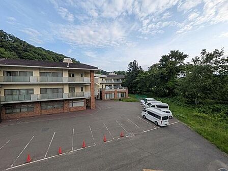 建物の周辺には緑があり自然を感じられます。開放感のある駐車スペースも確保されています。周囲は静かな環境で落ち着いた雰囲気です。現地からの眺望を楽しめるのが魅力です。