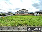 広々とした敷地が目を引く現地土地写真です。周囲には整然とした住宅が並び開放感のある環境です。晴れた日には明るい雰囲気が感じられます。建築プランも立てやすい形状となっています。