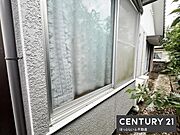 窓から見える緑が印象的な外観です。周囲の植栽がアクセントとなっています。窓のサイズも広めで採光に配慮されています。外壁の質感も落ち着いた雰囲気です。敷地内の動線もしっかり確保されています。
