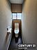 トイレ：シンプルなデザインのトイレです。窓があり採光が確保されています。程よい広さで日常使いに適しています。壁紙や床材も落ち着いた雰囲気です。ペーパーホルダーも使いやすい位置に設置されています。