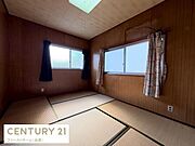 落ち着いた木目調の壁と畳が調和する広々とした和室です。大きな窓から自然光が入り室内は明るい印象です。畳の香りを感じられる空間で和の雰囲気が楽しめます。シンプルな内装でインテリアのアレンジも可能です。