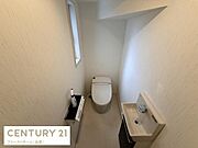 窓付きのトイレで自然な明るさが感じられます。手洗いスペースも独立しており使い勝手が良いです。清潔感のあるシンプルな空間です。壁や床のデザインも落ち着いた雰囲気です。