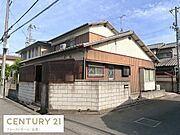 落ち着いた住宅街に位置する現地土地写真です。角地のため開放感があり日当たりも十分に確保されています。道路に面した立地で車の出入りもスムーズです。外壁や周囲のブロック塀も特徴となっています。