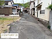 前面道路は舗装されており整った印象を受けます。周辺には住宅が並び落ち着いた街並みです。敷地前も広く車の出入りがしやすい環境です。周囲には緑も感じられ住みやすさが伝わります。