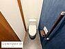 トイレ：落ち着いた色合いの壁面が印象的なトイレです。手すりが設置されており使いやすさに配慮されています。床はお手入れしやすい素材が使用されています。トイレ空間がすっきりとまとまっています。