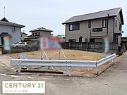 周囲に住宅が建ち並ぶ現地土地写真です。敷地は整地されており住宅用地としてさまざまな活用が可能です。道路に面した区画で車の出入りも便利です。静かな住環境が印象的な一角です。