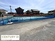 現地土地写真では平坦で整備された敷地が広がっています。周囲には住居が点在し落ち着いた雰囲気が感じられます。道路に面しているためアクセスも便利です。