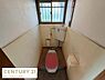 トイレ：窓付きで明るさを感じられるトイレです。シンプルなレイアウトで使い勝手が良い空間です。壁のタイルが清潔感を演出します。床にはマットが敷かれているため足元でも安心です。換気にも配慮された設計です。