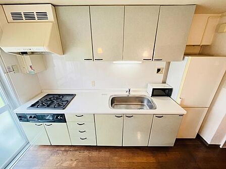清潔感あふれる明るいキッチンです!豊富な上下の収納棚、広々としたシンク、便利な3口ガスコンロを完備。大きな窓からの採光も良く、毎日のお料理が快適に楽しめる実用的な空間となっています。