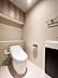 トイレ：白を木目を基調とした清潔感のあるトイレです。※AIによる画像加工を行っております。