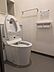 トイレ：清潔感のあるトイレ空間です。収納棚付きで使い勝手にも配慮されています。壁面にはペーパーホルダーが設置されています。シンプルな内装が印象的です。
