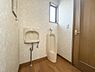 トイレ：窓から自然光が入り明るい印象のトイレです。手洗い器も設置されており使い勝手に配慮されています。床材と壁紙の組み合わせが清潔感を演出しています。ドアや水まわりの設備もしっかりと設置されています。
