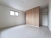 明るいフローリングと木目のアクセントウォールが特徴的な洋室です。クローゼットが備わっており収納スペースも確保されています。シンプルな内装で幅広いインテリアに合わせやすい空間です。
