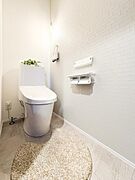 白を基調とした明るく清潔感のあるトイレです。落ち着いた色合いの壁面が空間に清潔感を感じさせます。