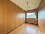 壁と床が木目調でまとまった洋室です。シンプルなデザインでインテリアのレイアウトも自由自在です。天井には照明が設置されており使い勝手の良い空間となっています。