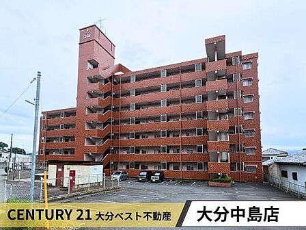 赤茶色の外観が特徴的なマンションです。広めの敷地内に駐車スペースが確保されています。階段やバルコニー部分がアクセントとなり全体に落ち着いた印象を与えます。