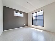 大きな窓から光が差し込む明るく開放感のある洋室です。壁の一部がアクセントカラーになっておりシンプルなデザインが魅力です。