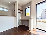 大きな窓から自然光がたっぷり差し込むリビングです。ダークブラウンのフローリングが落ち着いた雰囲気を演出します。カウンター付きで使い勝手も良好です。